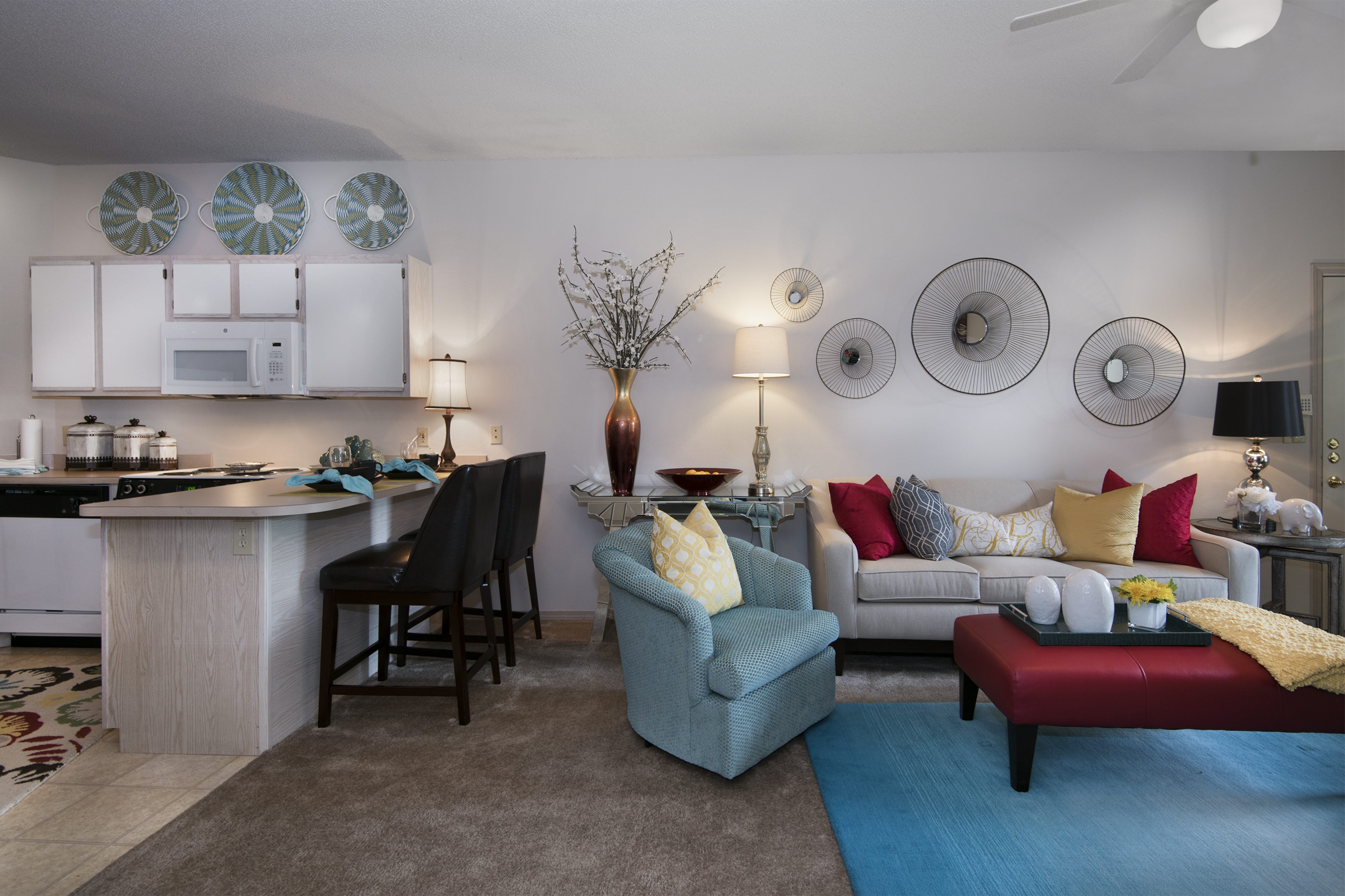 A living room with a grey couch and a red coffee table.